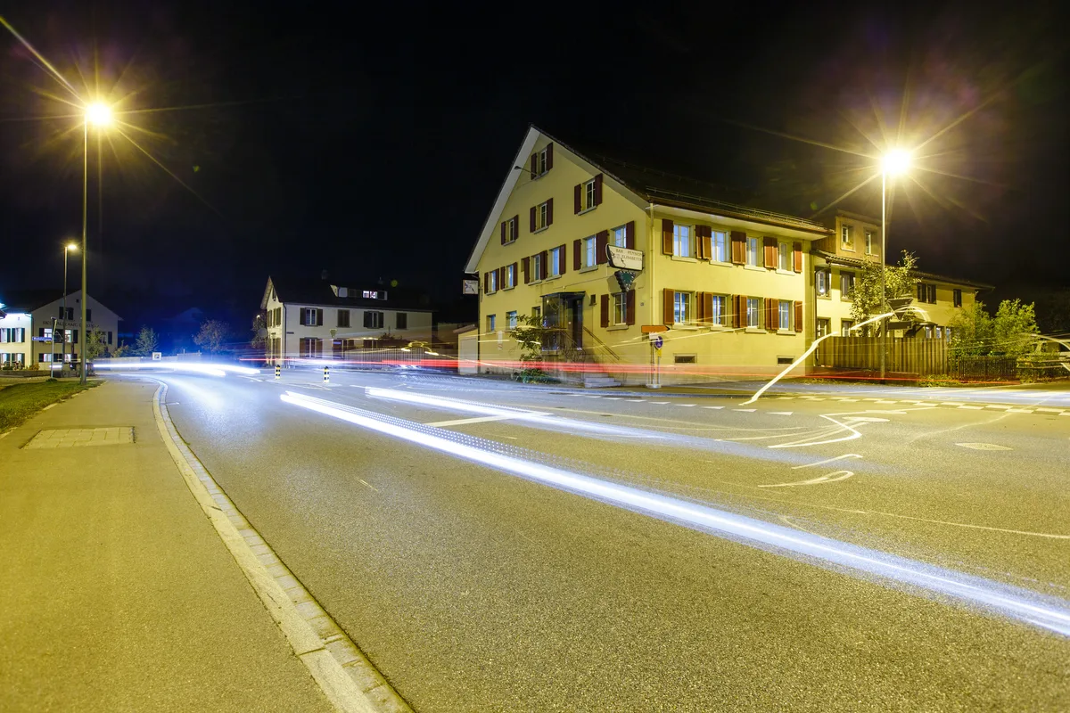 Ein Haus in der Nacht an einer Strasse. 